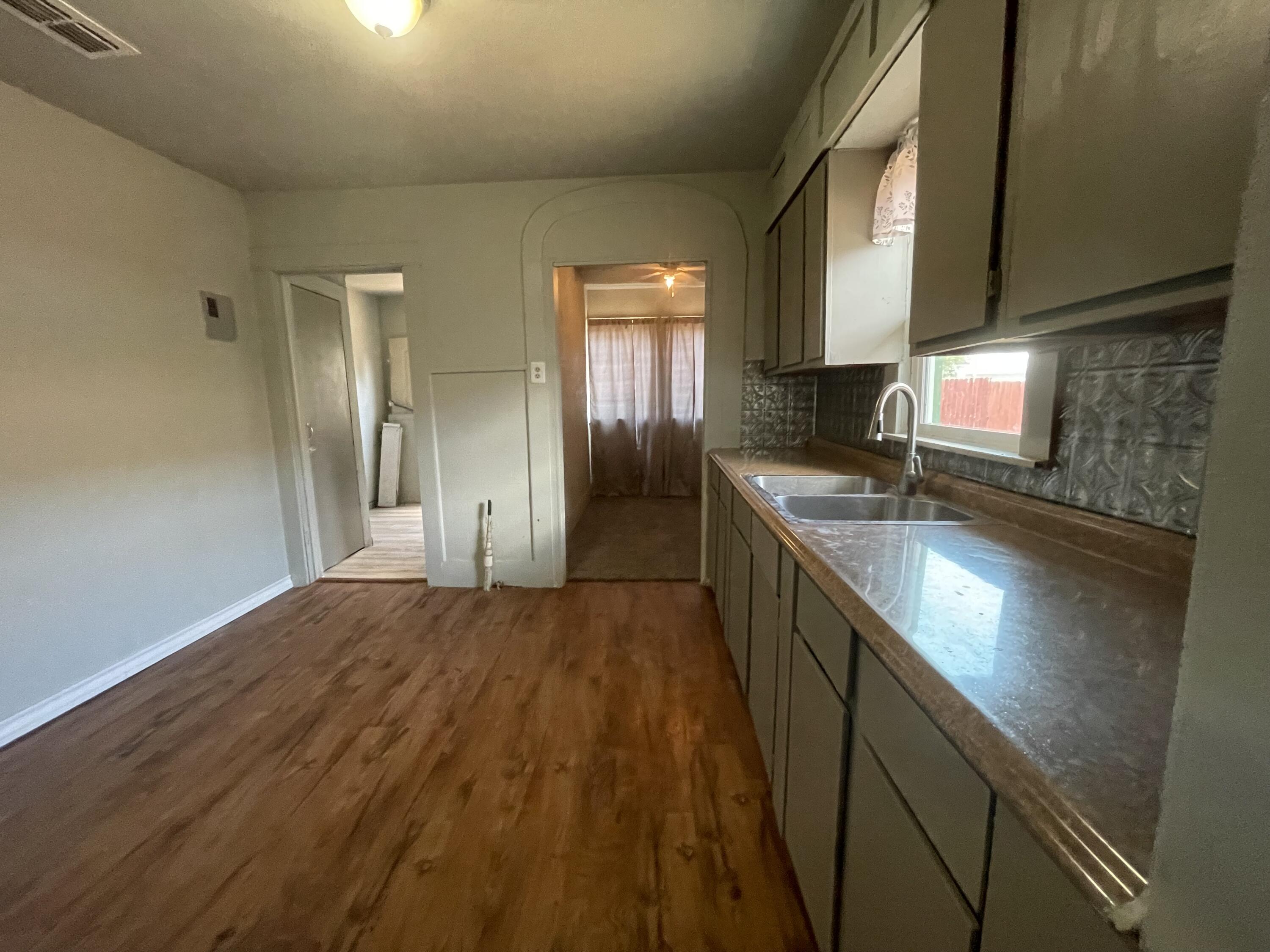 325 South 13th Street Slaton, TX 79364 - Photo 25 of 35 a kitchen with stainless steel appliances granite countertop a sink a stove and a refrigerator