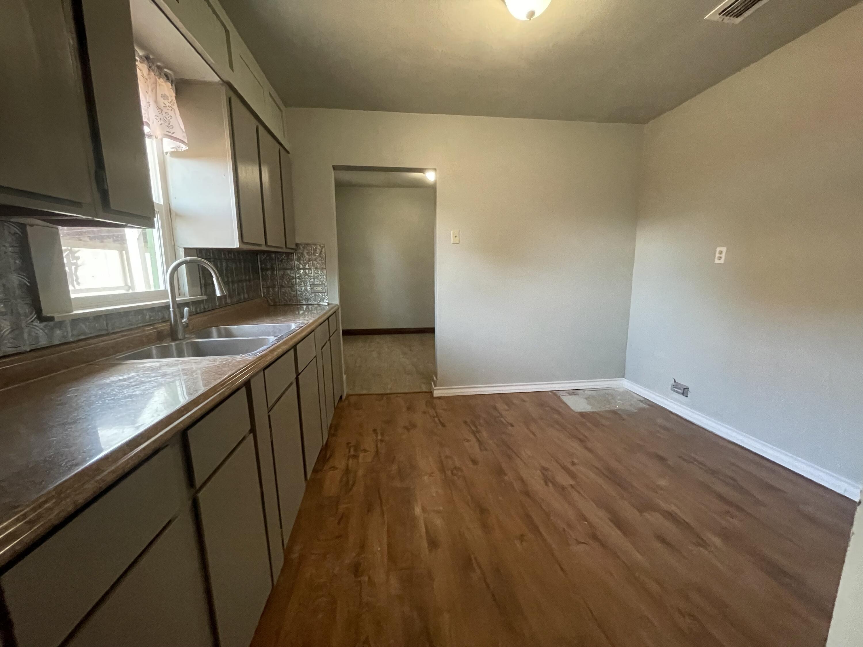 325 South 13th Street Slaton, TX 79364 - Photo 26 of 35 a kitchen with granite countertop sink and cabinets