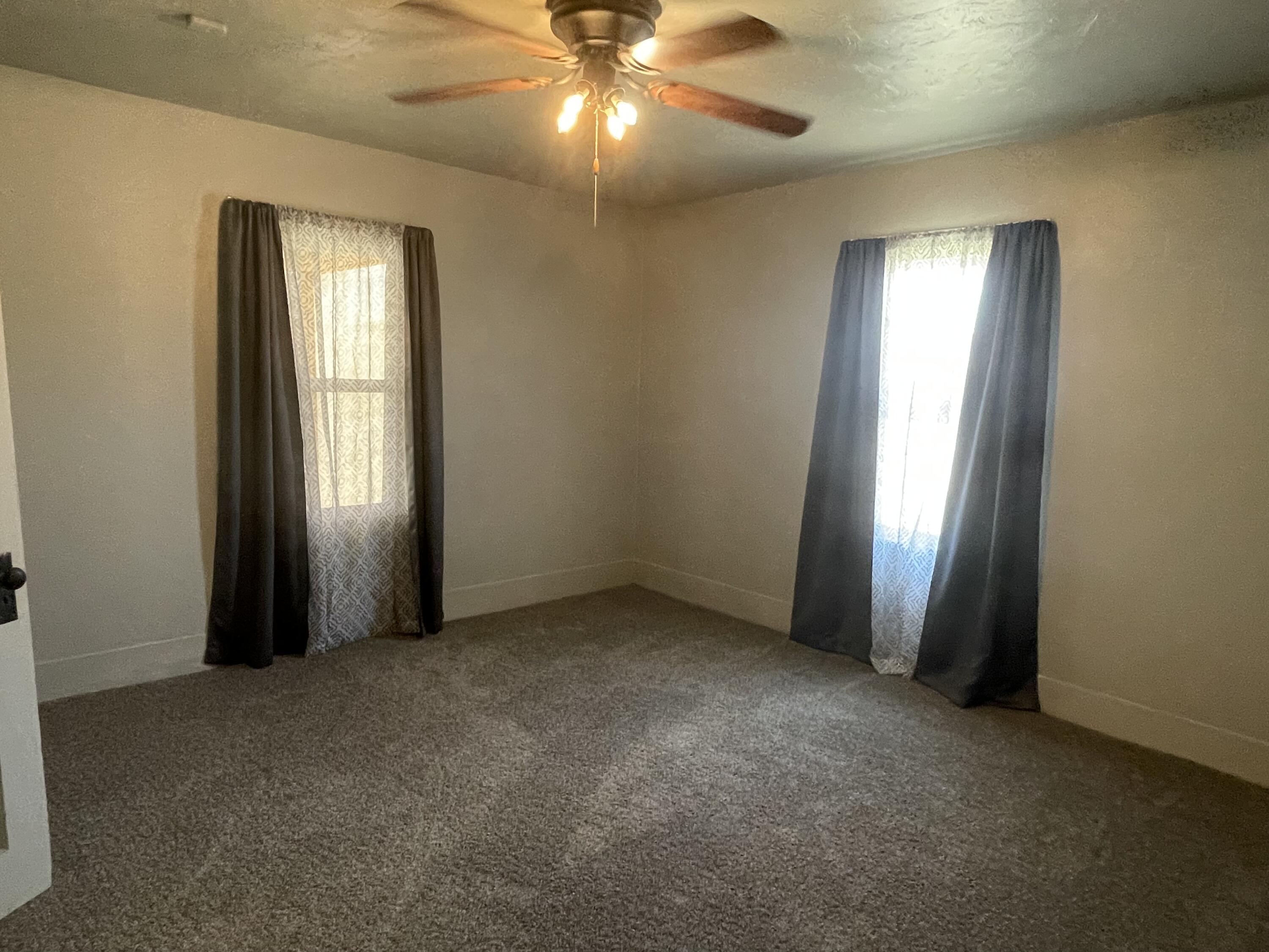 325 South 13th Street Slaton, TX 79364 - Photo 27 of 35 an empty room with windows and chandelier fan