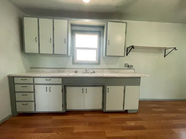 a kitchen with a sink cabinets and a window