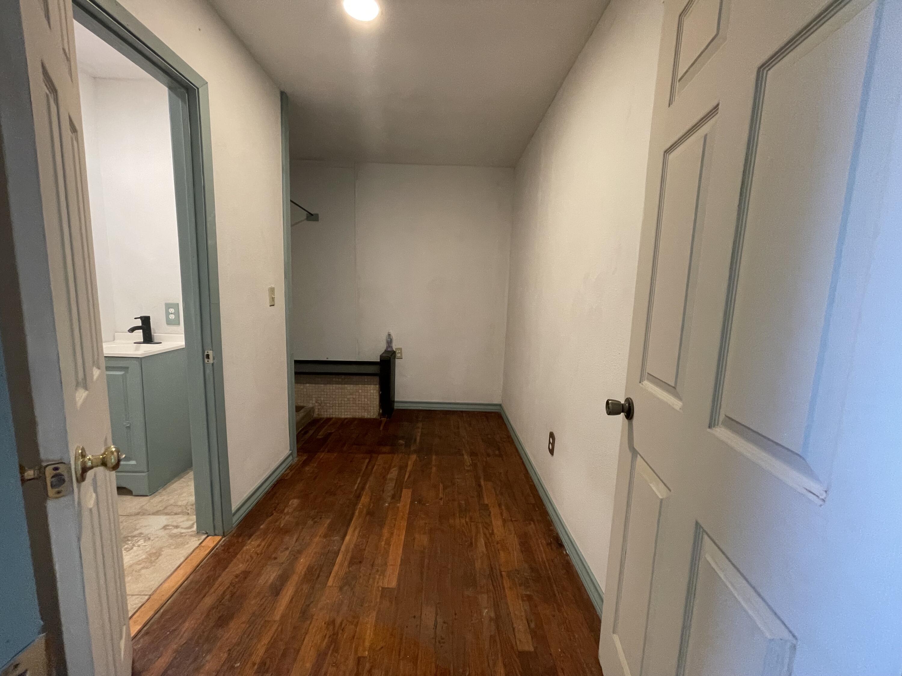 325 South 13th Street Slaton, TX 79364 - Photo 7 of 35 a view of a hallway with wooden floor and staircase