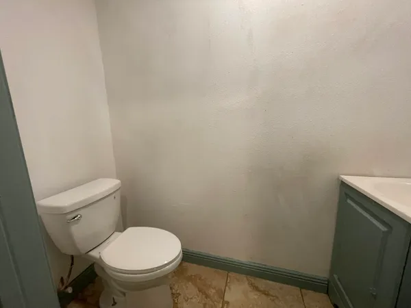 a white toilet sitting next to a shower