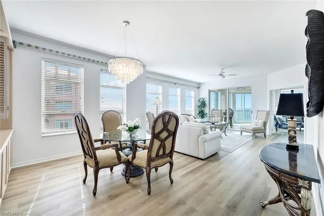 a dining room with furniture a chandelier and wooden floor