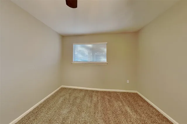 a view of an empty room with wooden floor and windows