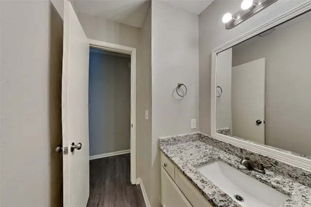 a bathroom with a granite countertop sink and a mirror