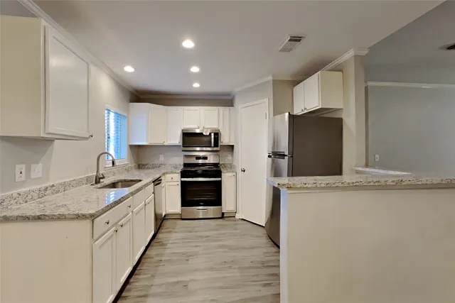 a kitchen with stainless steel appliances granite countertop a refrigerator stove microwave and sink