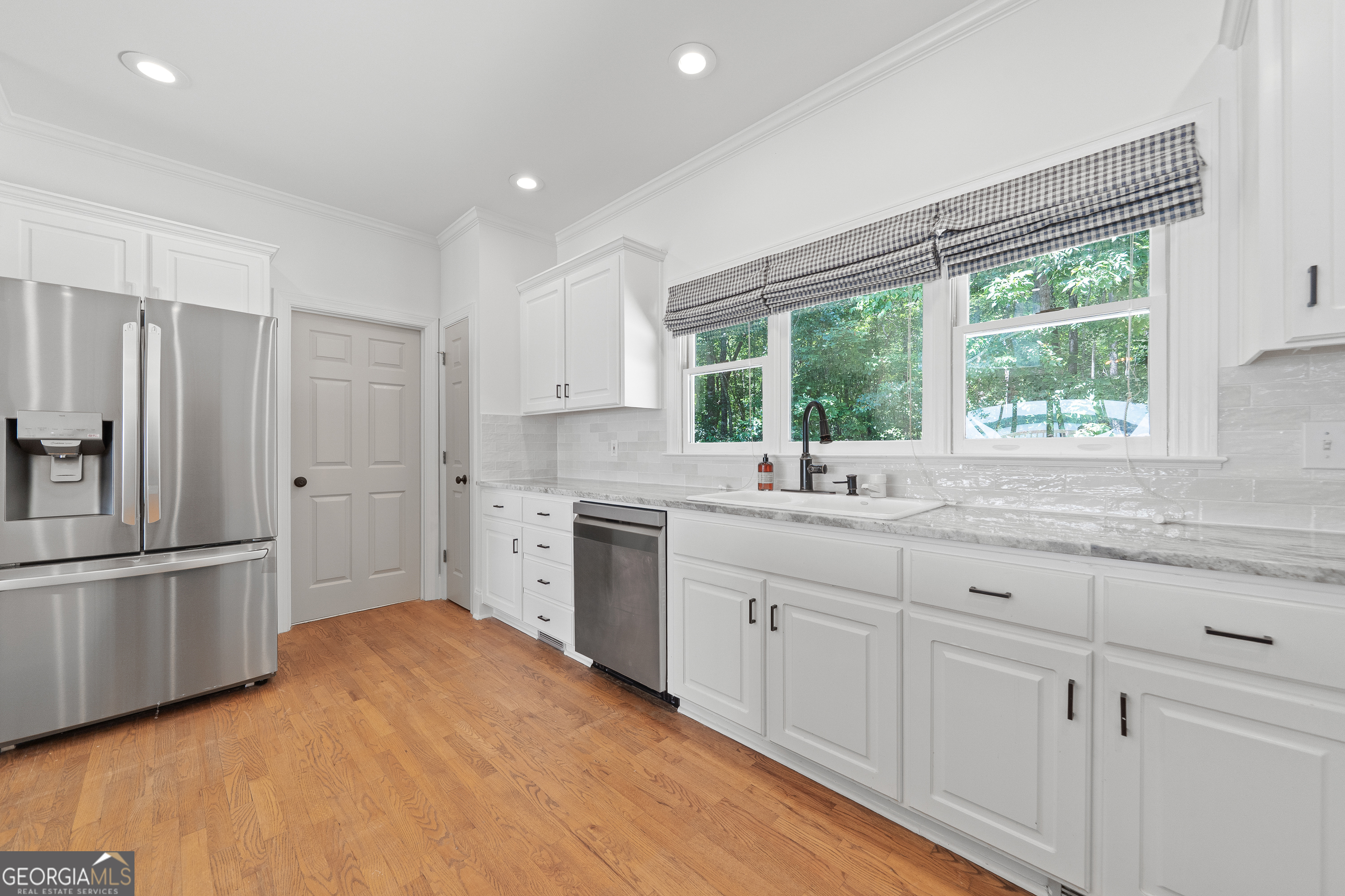 264 Winding River Road Eatonton, GA 31024 - Photo 16 of 72 a kitchen with white cabinets and a window