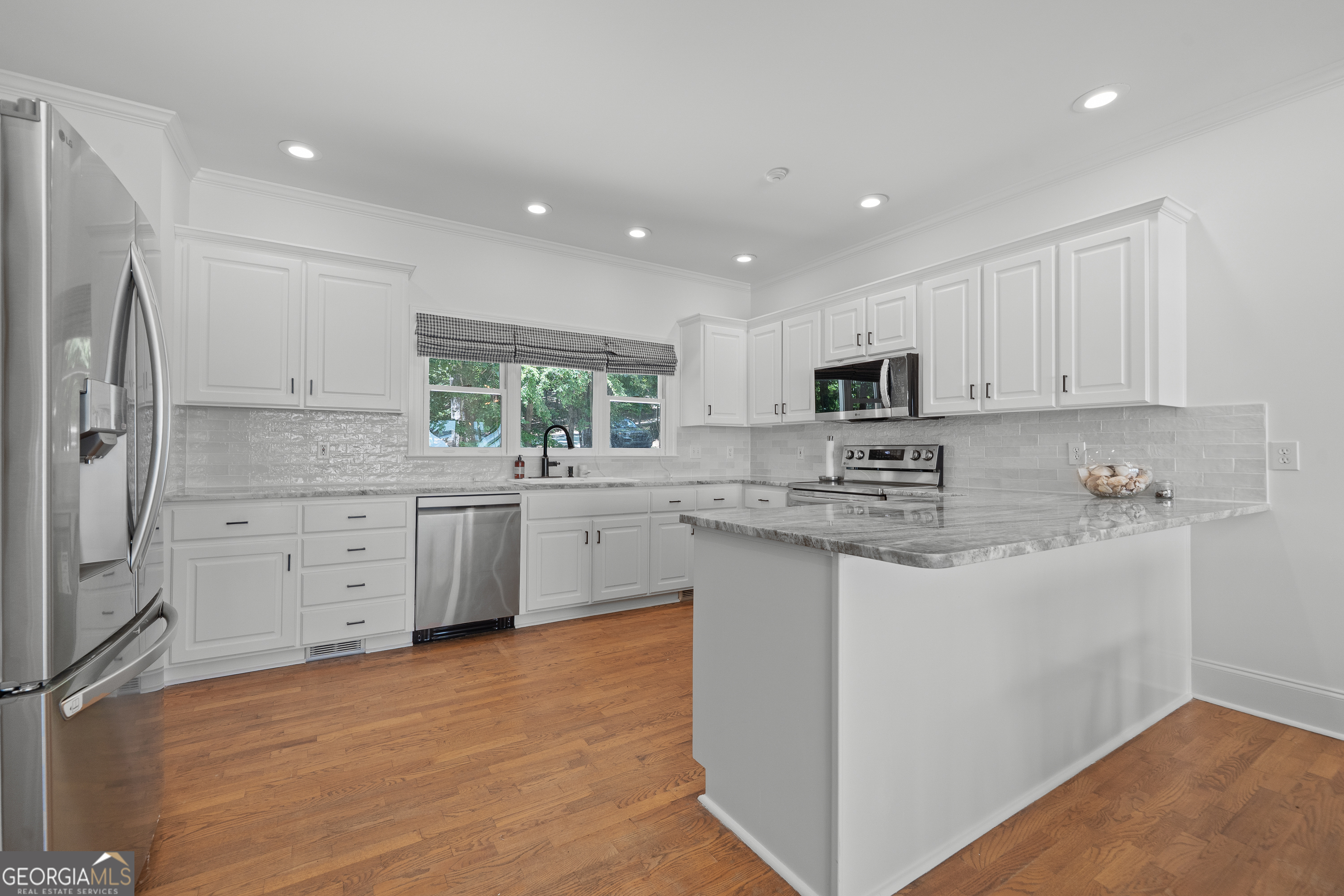264 Winding River Road Eatonton, GA 31024 - Photo 18 of 72 a kitchen with white cabinets stainless steel appliances and a sink