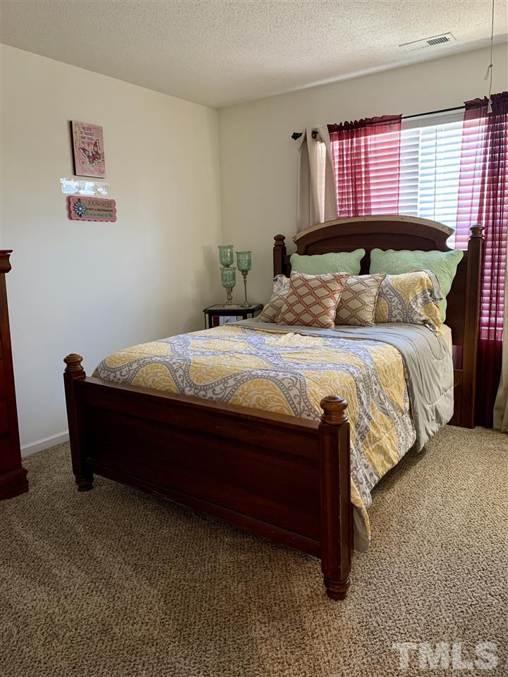 506 Huron Road Raleigh, NC 27610 - Photo 25 of 29 a bed sitting in a bedroom next to a window