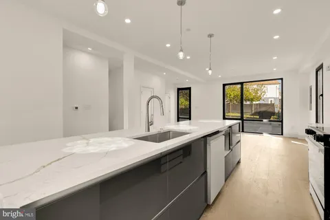 a large kitchen with kitchen island a large window and a sink