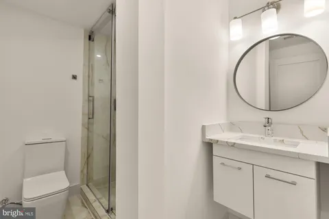a bathroom with a toilet a sink and mirror