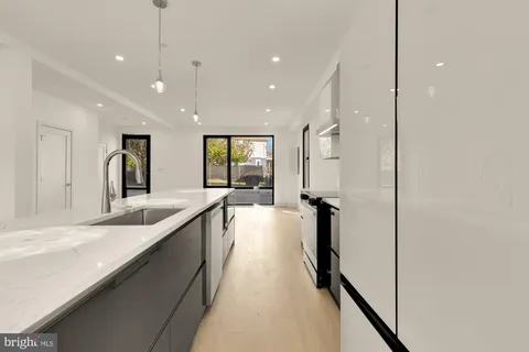 a large kitchen with kitchen island a large counter top space a sink and stainless steel appliances