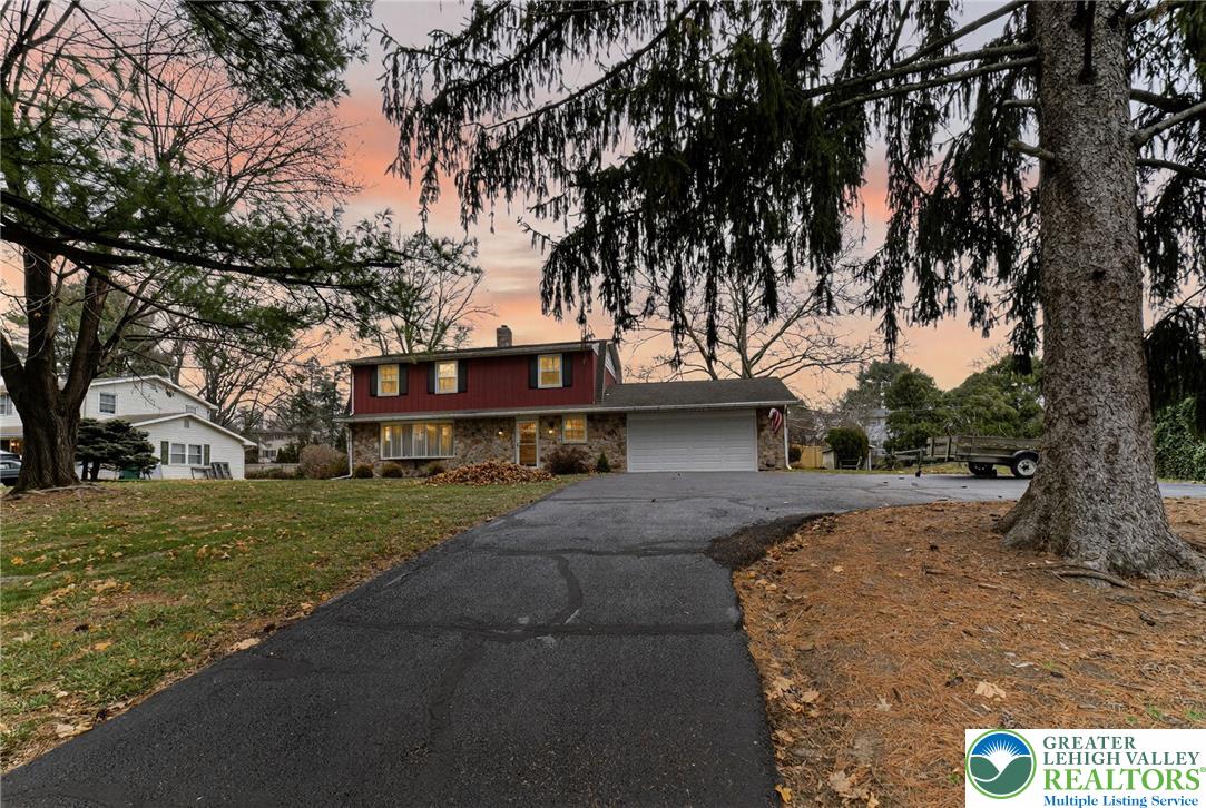 a front view of a house with a yard and trees