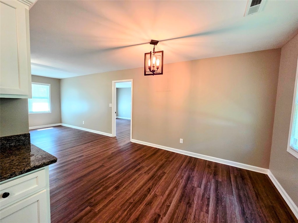 509 Elrod Road Piedmont, SC 29673 - Photo 7 of 28 Rich hardwood-style flooring extends through this open-concept area, leading to an adjoining room.