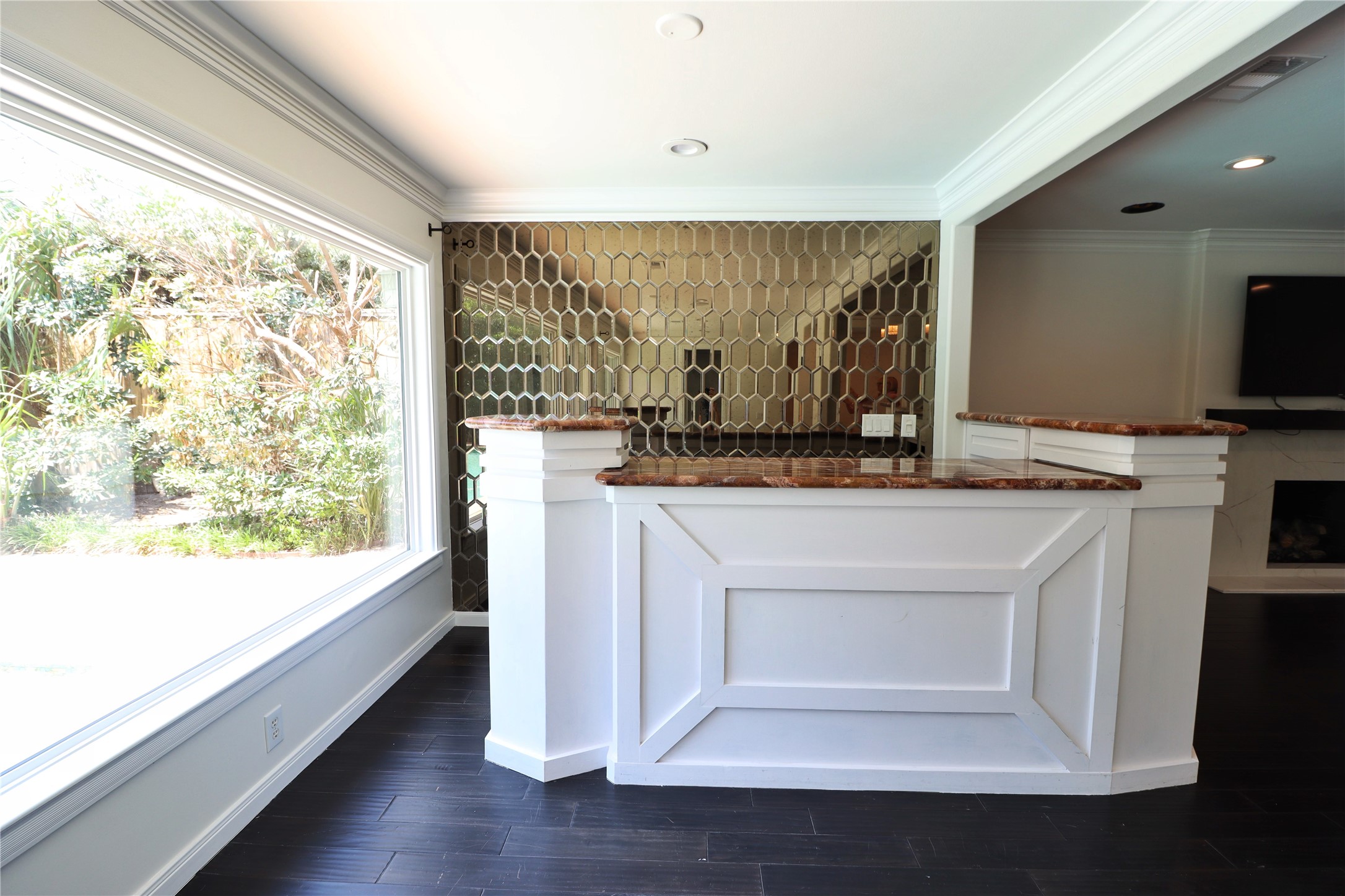 2003 Chilton Road Houston, TX 77019 - Photo 7 of 17 Here is a close-up of the custom built-in bar featuring handsome stone countertops, custom millwork, and an art deco mirrored accent wall that reflects natural light from the oversized picture window. This bar is an attractive connector between the formal living room and the casual entertaining space.