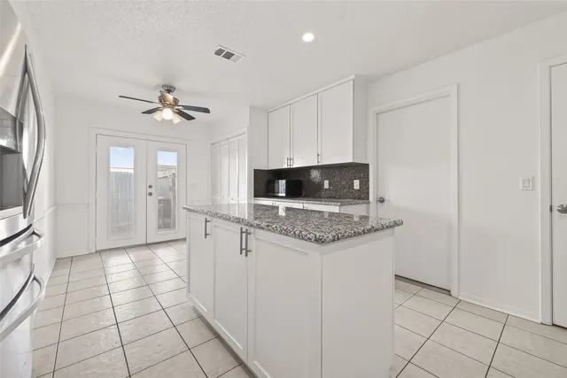 a kitchen with granite countertop a sink appliances and cabinets