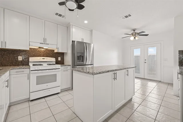 a kitchen with granite countertop cabinets stainless steel appliances and a counter space