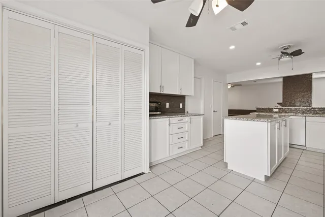 a kitchen with a refrigerator sink and cabinets
