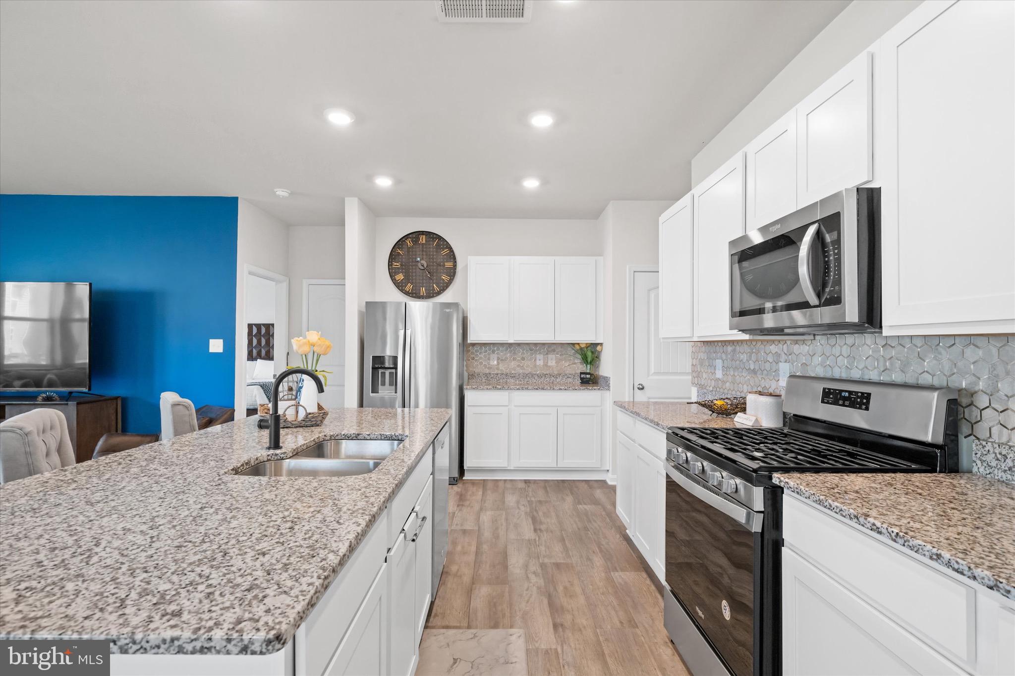 735 Red Maple Road Smyrna, DE 19977 - Photo 18 of 42 a kitchen with stainless steel appliances granite countertop a sink stove microwave and cabinets