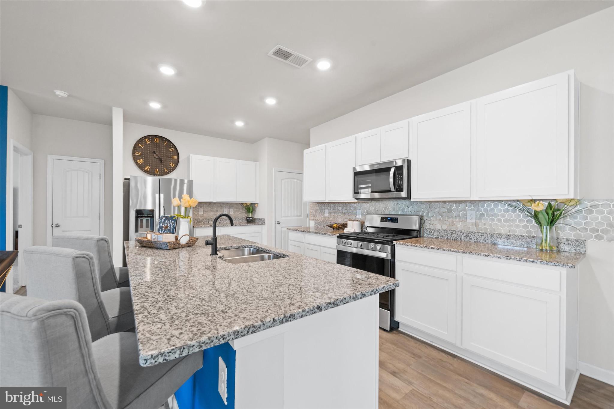 735 Red Maple Road Smyrna, DE 19977 - Photo 19 of 42 a kitchen with granite countertop kitchen island sink stove and microwave