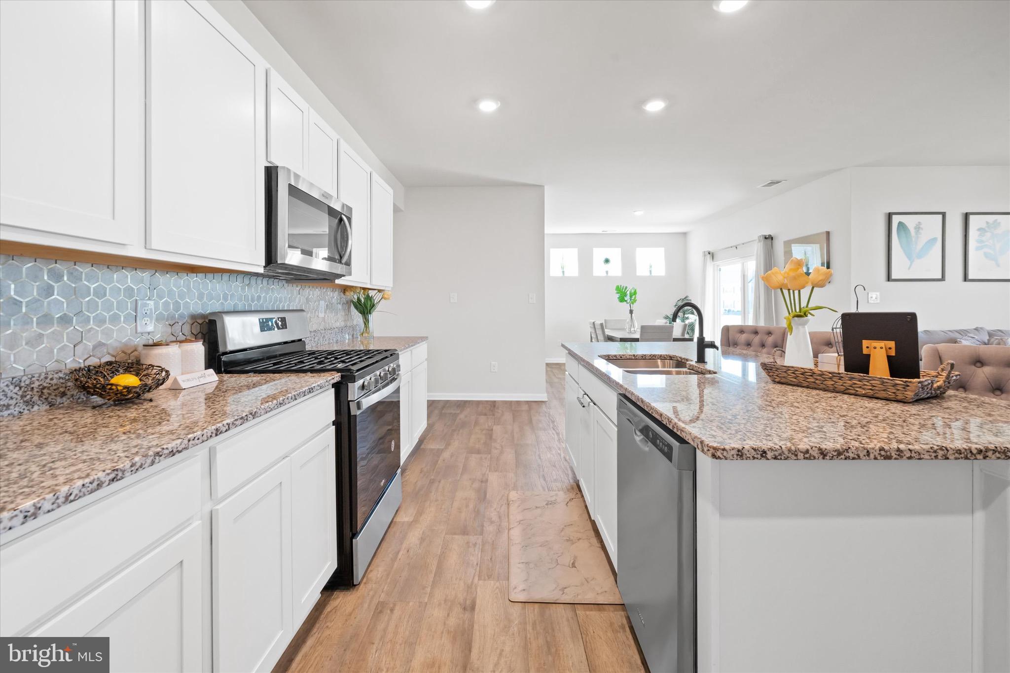 735 Red Maple Road Smyrna, DE 19977 - Photo 20 of 42 a kitchen with stainless steel appliances granite countertop a sink stove and cabinets