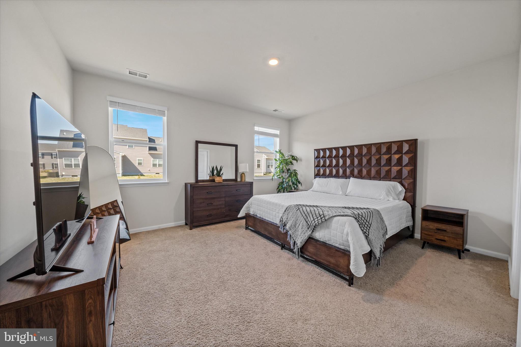 735 Red Maple Road Smyrna, DE 19977 - Photo 21 of 42 a spacious bedroom with a bed and wooden floor
