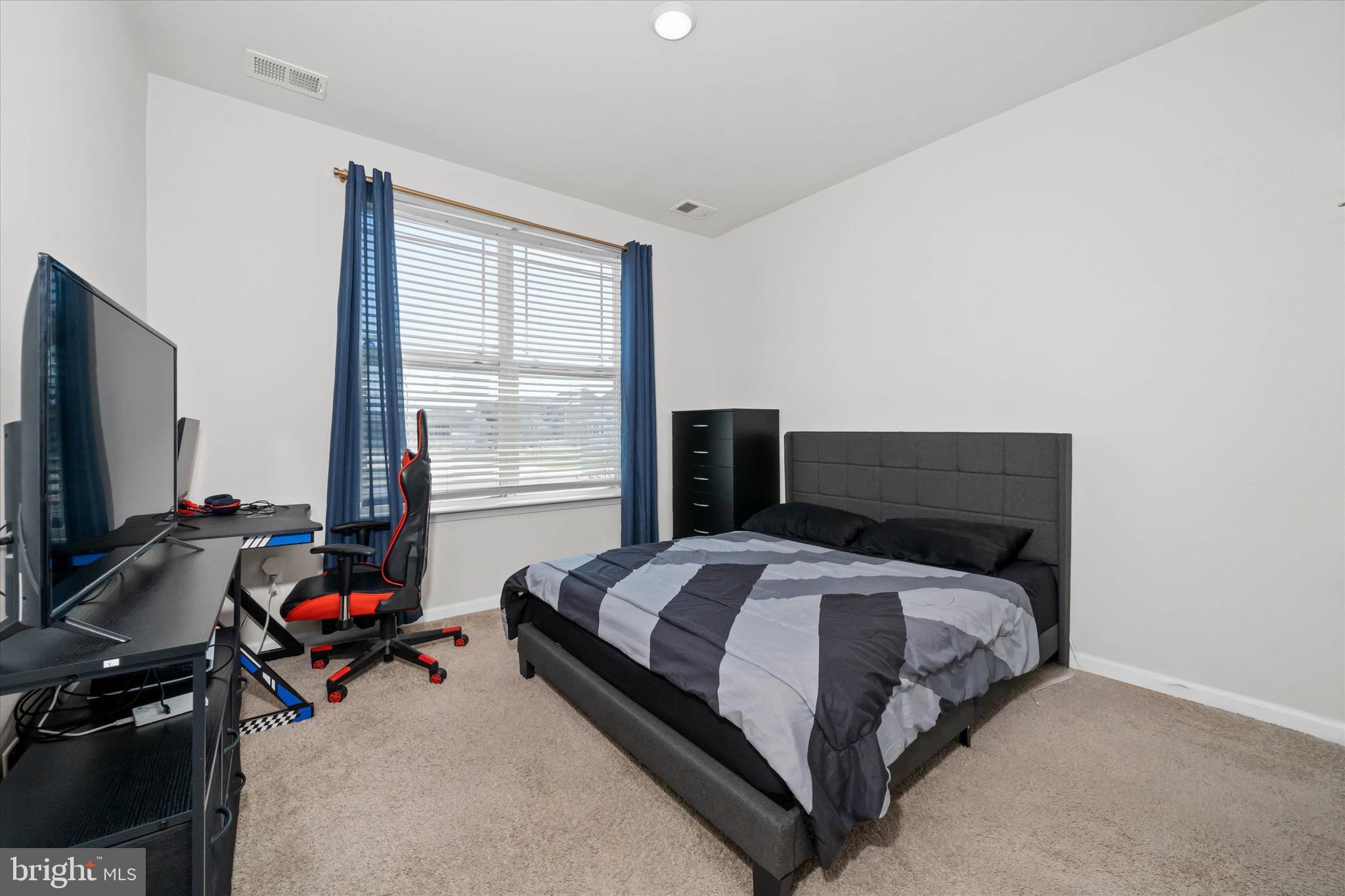 735 Red Maple Road Smyrna, DE 19977 - Photo 26 of 42 a bedroom with a bed and a flat tv screen