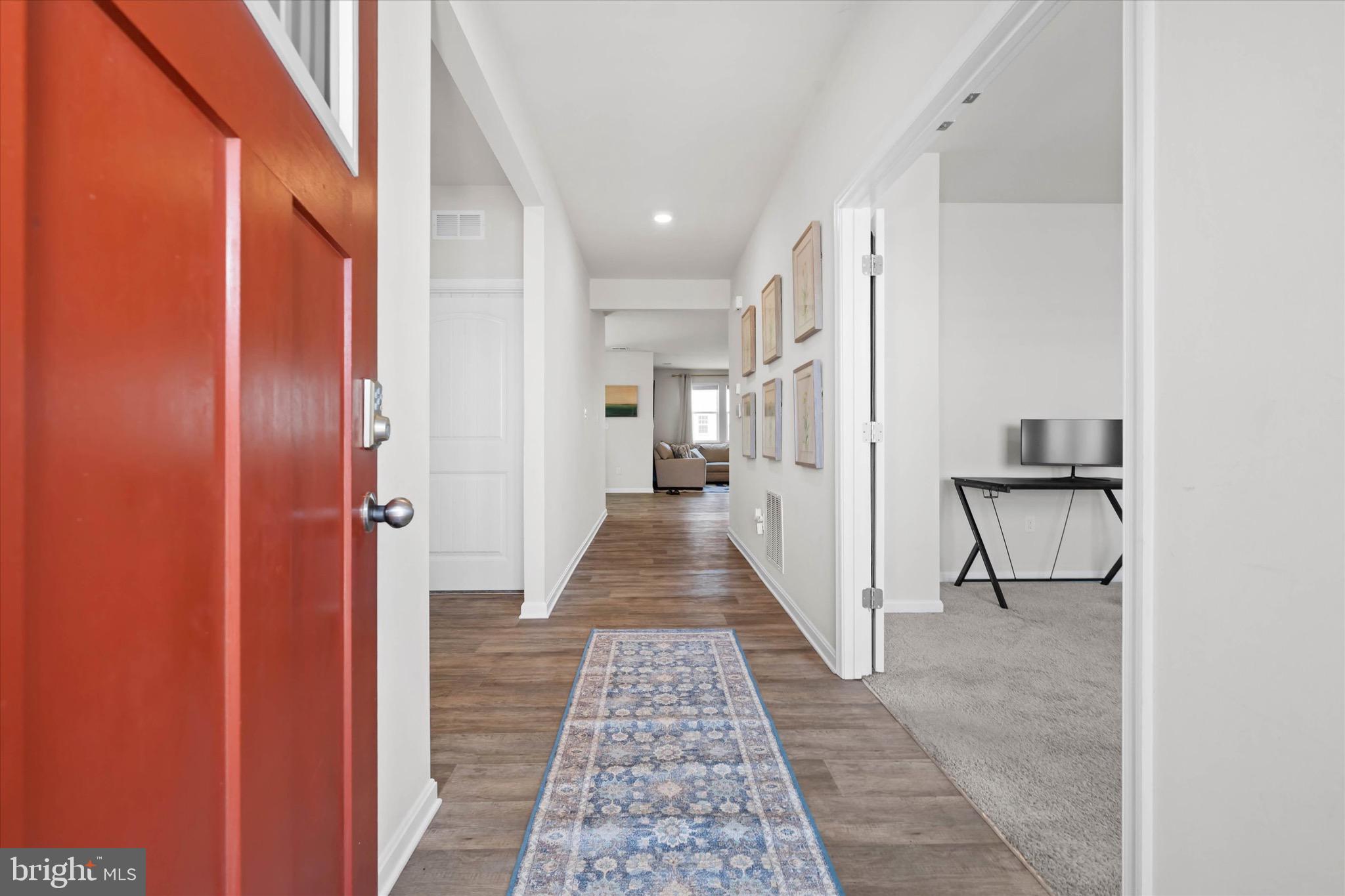 735 Red Maple Road Smyrna, DE 19977 - Photo 7 of 42 a view of a hallway with a couch and a dining table