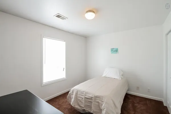 a bedroom with a bed and a window