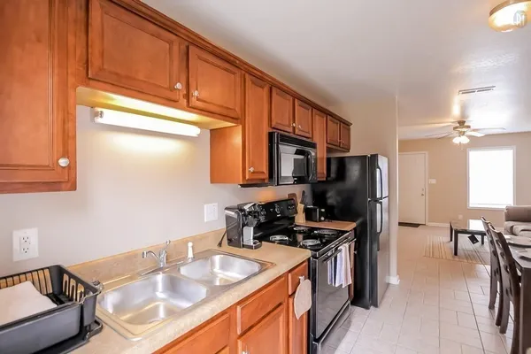 a kitchen with stainless steel appliances a sink a stove cabinets and a dining table