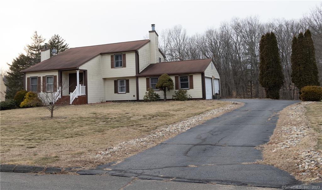 a front view of a house with a yard and trees