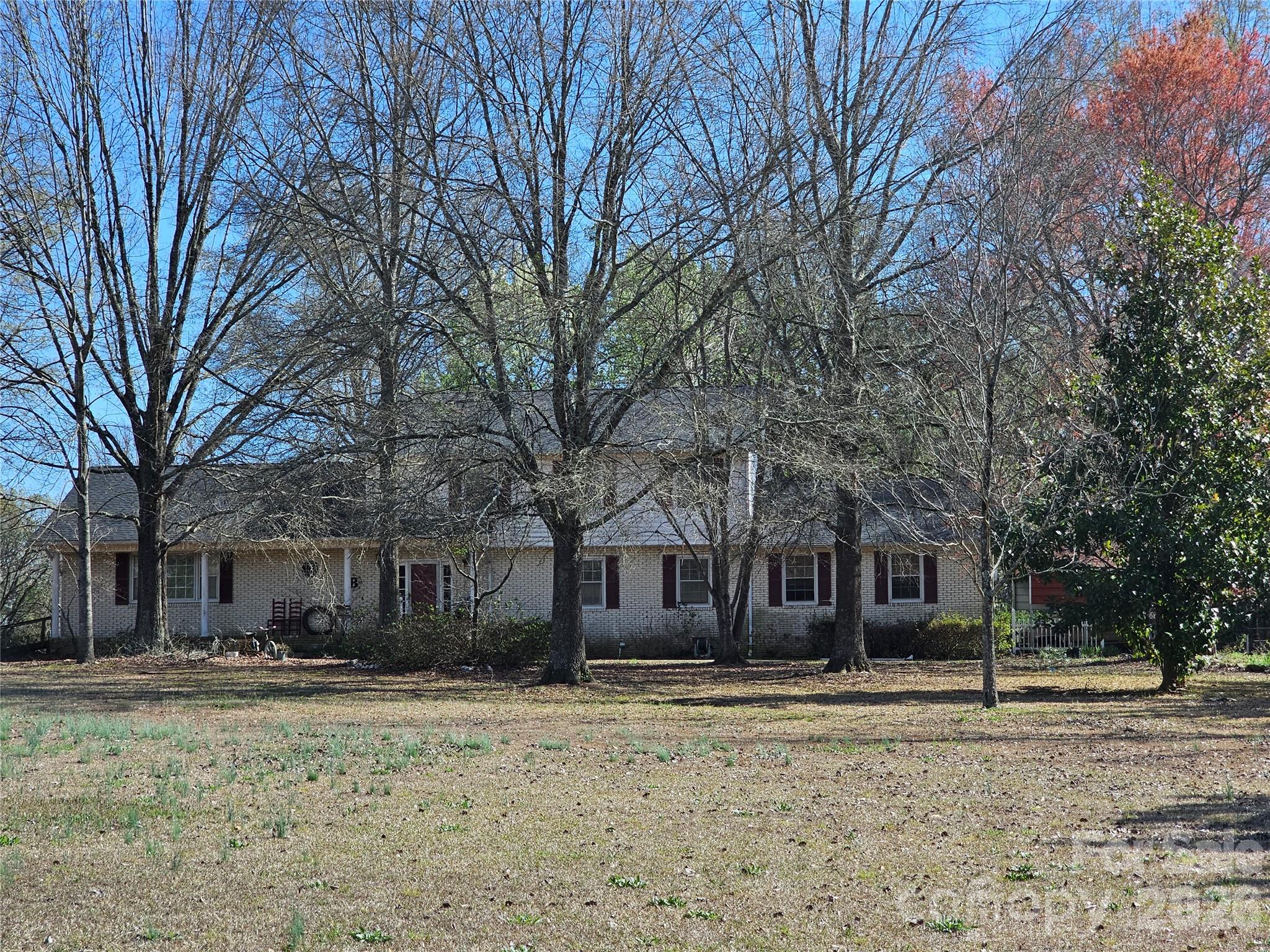 a front view of a house with a yard and trees