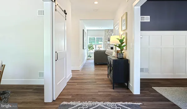 a view of a hallway view with wooden floor and living room