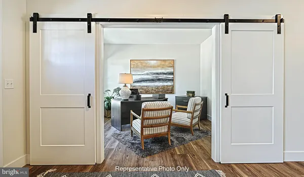 a view of a hallway to a livingroom with furniture and wooden floor
