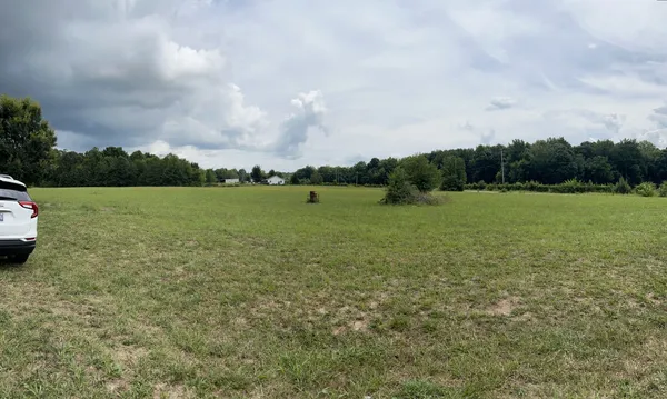 a view of a field with an trees in the background