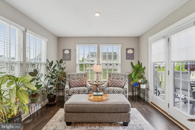a living room with patio furniture and a potted plant