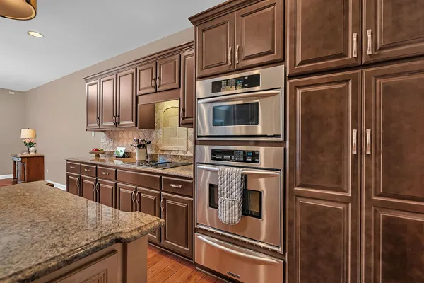 a kitchen with stainless steel appliances granite countertop a refrigerator a stove and a sink