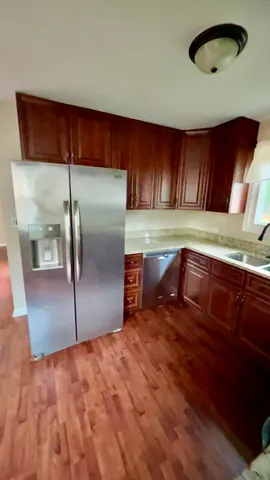 a kitchen with stainless steel appliances granite countertop a refrigerator a sink and a stove