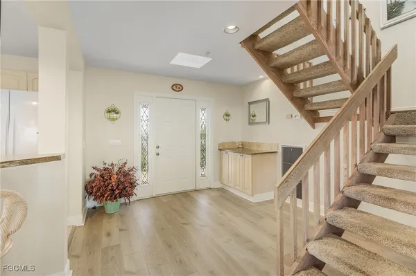 a view of entryway and hall with wooden floor