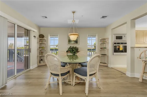 a dining room with furniture a chandelier and wooden floor