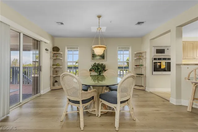 a dining room with furniture a chandelier and wooden floor
