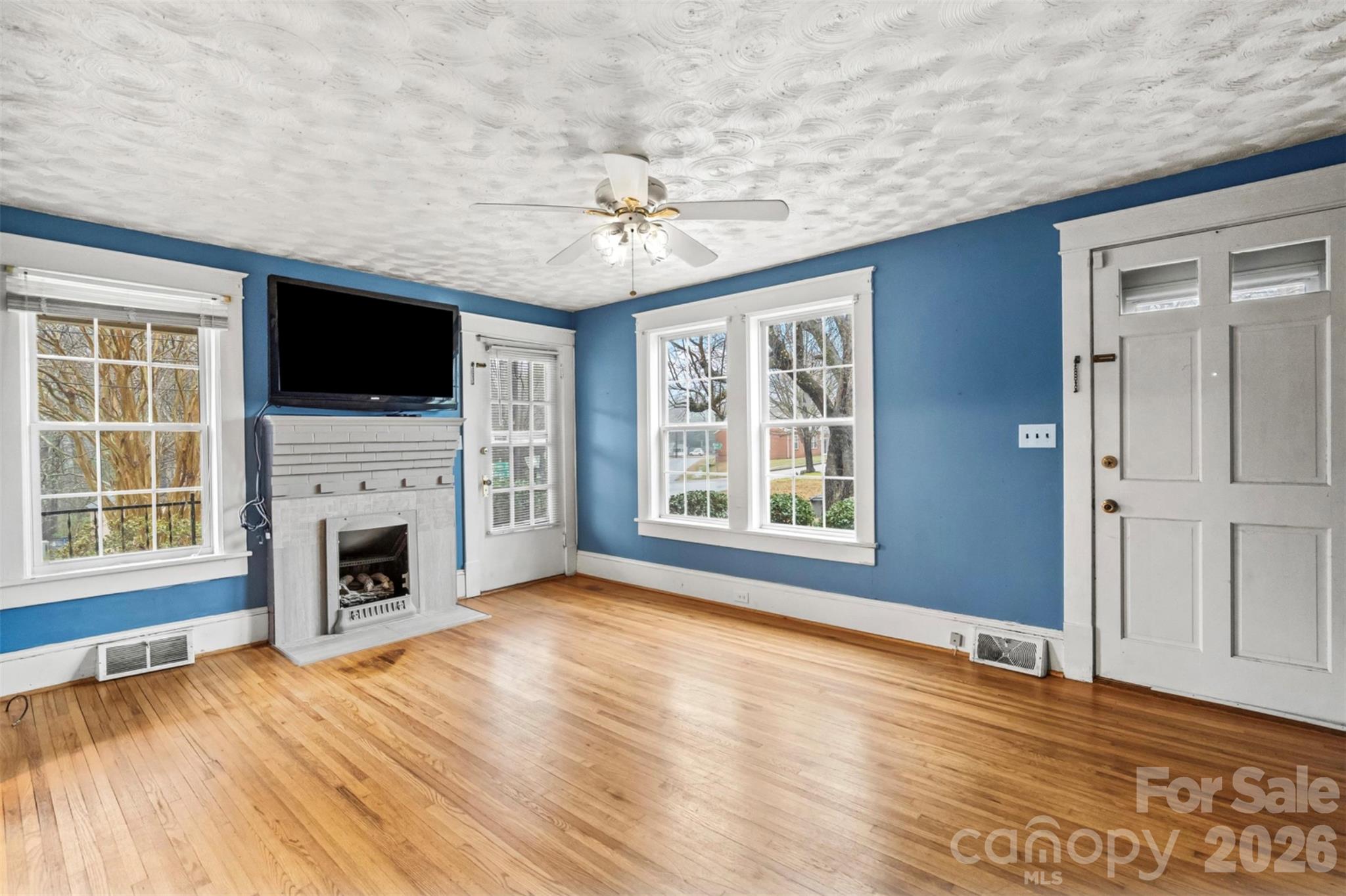 1409 Venus Street Kannapolis, NC 28083 - Photo 2 of 22 an empty room with windows fireplace and flat screen tv