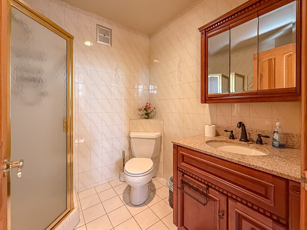 13581 Solitude Trail Machipongo, VA 23405 - Photo 15 of 51 a bathroom with a granite countertop sink a toilet and a mirror