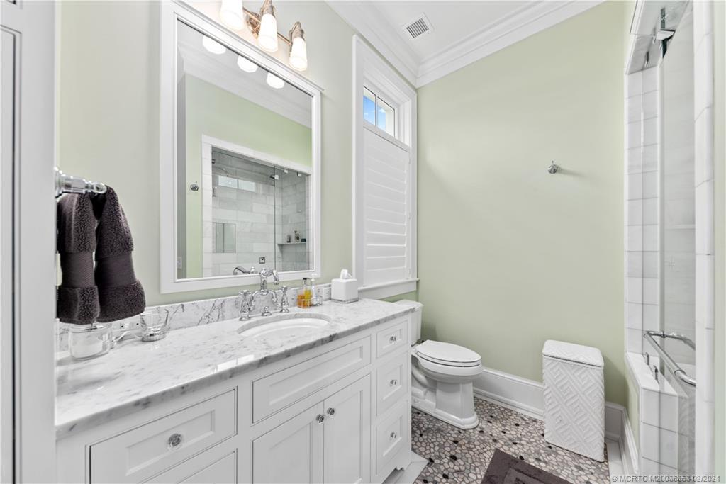 1441 Southeast Riverside Drive Stuart, FL 34996 - Photo 30 of 73 a bathroom with a granite countertop sink toilet and mirror