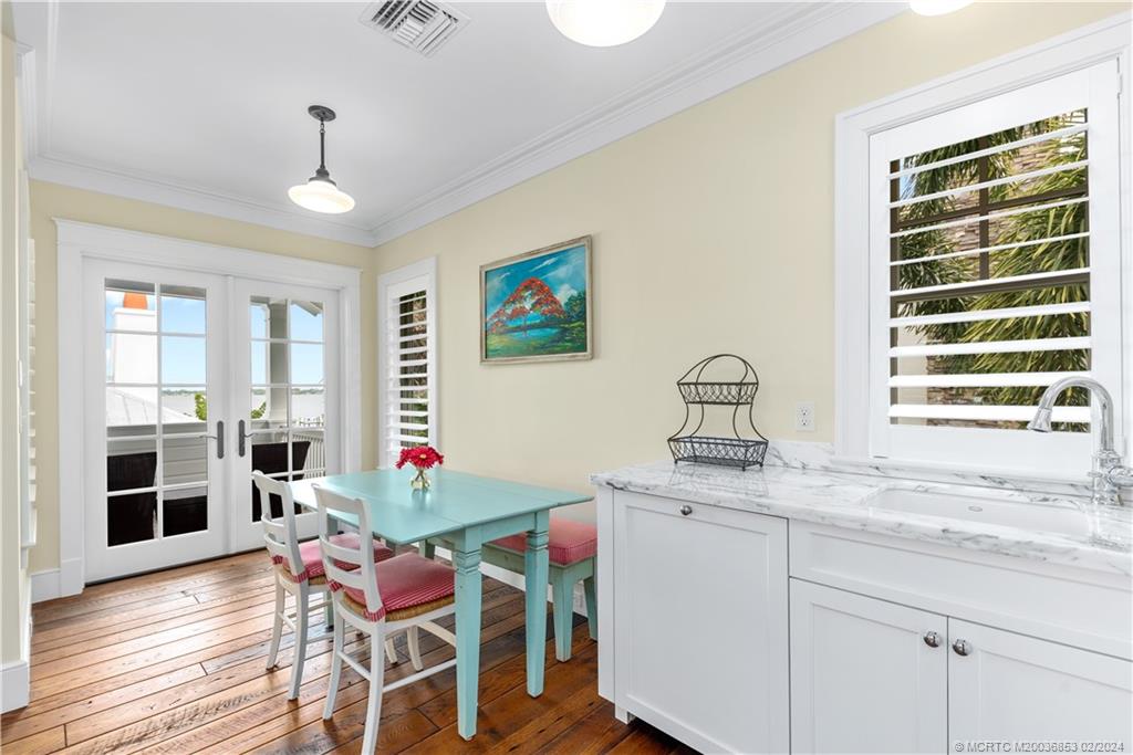 1441 Southeast Riverside Drive Stuart, FL 34996 - Photo 64 of 73 a kitchen with a stove a sink dishwasher a dining table and chairs with wooden floor