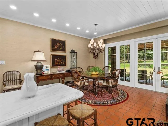 a dining room with furniture a rug and a chandelier