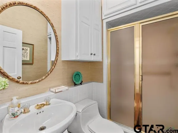 a bathroom with a sink mirror vanity and toilet
