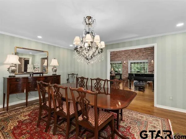 a view of a dining room with furniture a chandelier and wooden floor