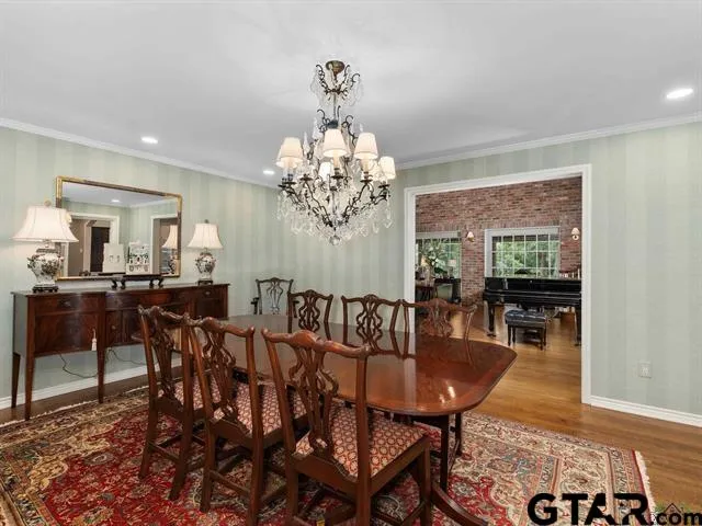 a view of a dining room with furniture a chandelier and wooden floor
