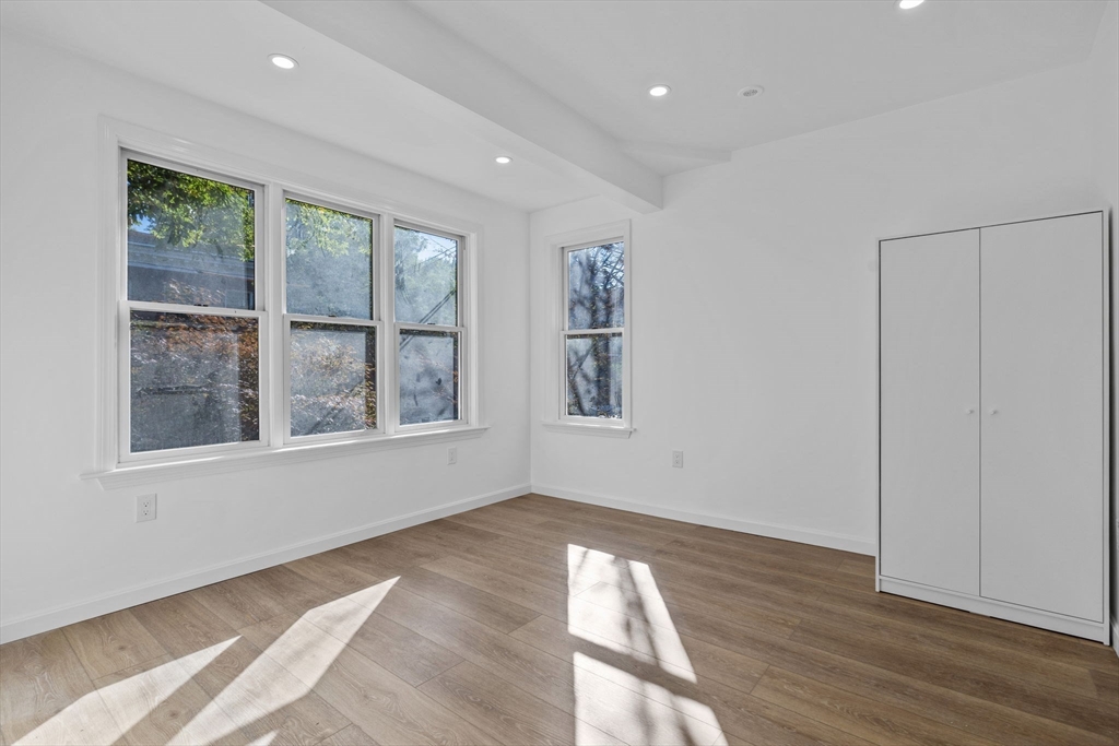172 Lexington Avenue, Unit 1 Cambridge, MA 02138 - Photo 12 of 19 a view of empty room with wooden floor and fan